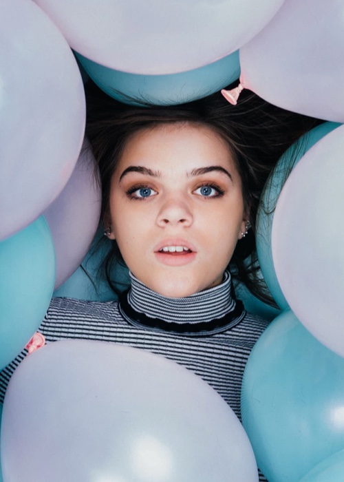 Woman in striped shirt surrounded by balloons