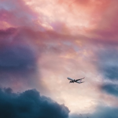 Airplane flying through colourful clouds